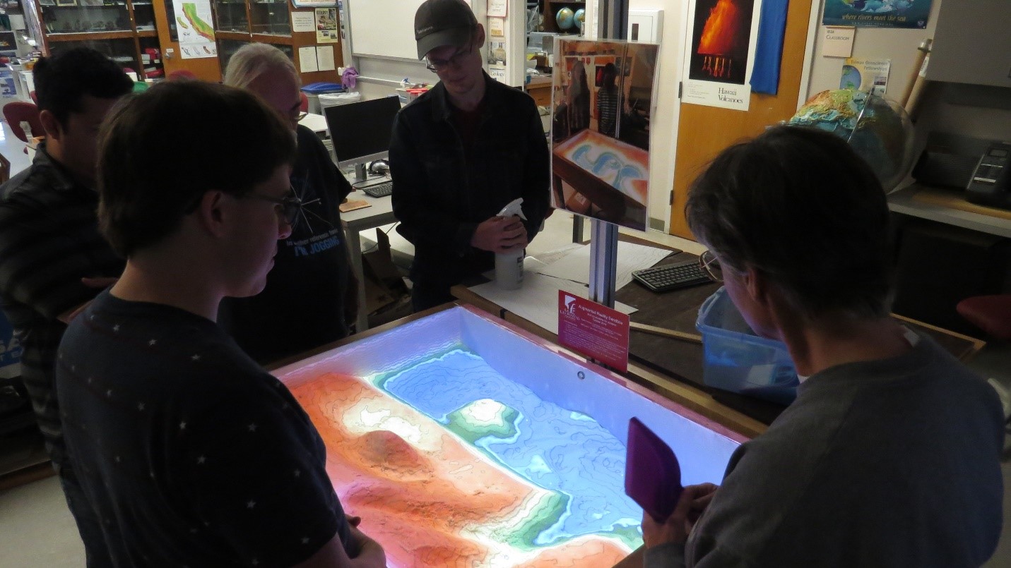 Instructor Ruth Hanna models a shoreline with a headland and a bay.