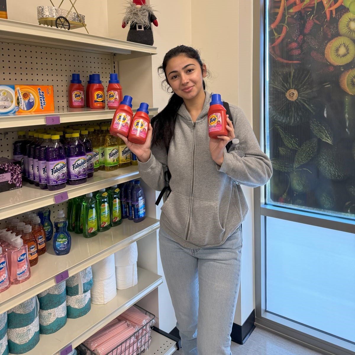 student in the mini market holding up laundry detergent