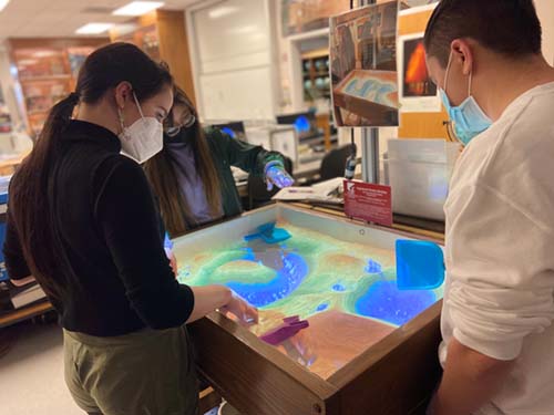 Geology students playing with the AR Sandbox