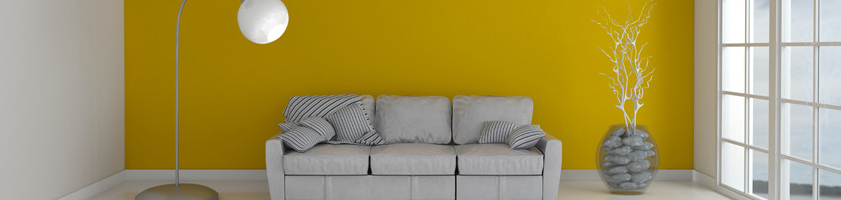 Sofa and lamp in yellow room with window.